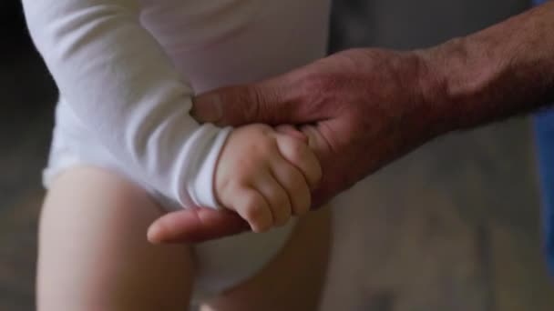 Zbliżenie pomarszczonej dłoni dziadka w wieku 50 lat i małych dłoni dziecka. — Wideo stockowe