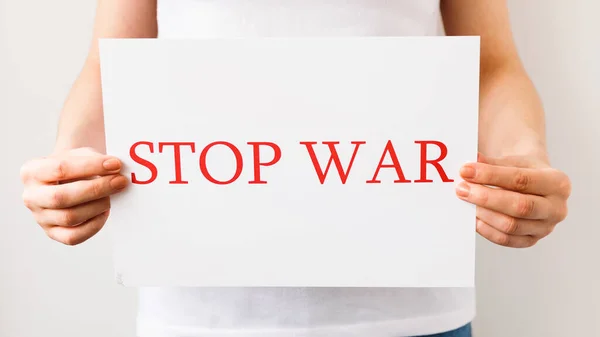 Close up of a Protester hands holding cardboard Banner with the words stop war protesting against the Russian invasion. — Stock fotografie