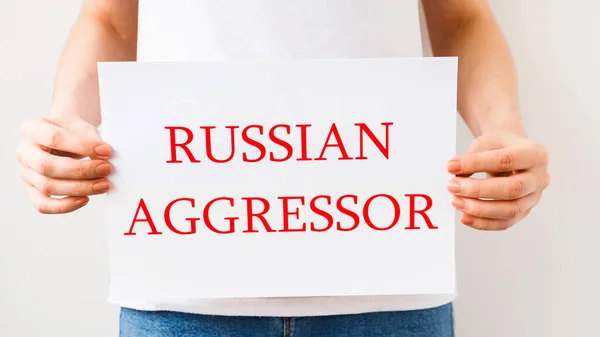 Закрыть руки протестующего, держащего картонное знамя со словами "русский агрессор". — стоковое фото