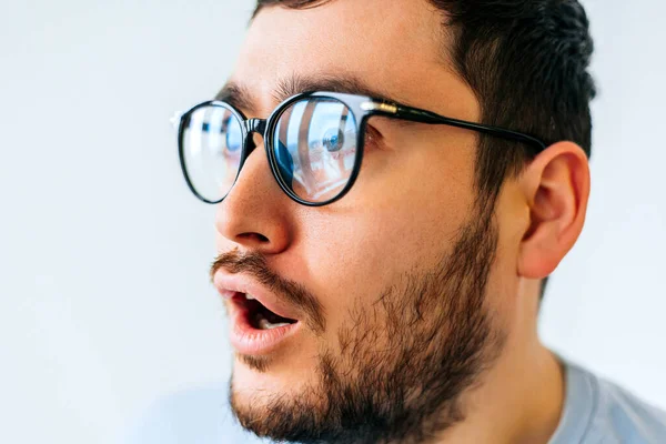 Skäggig man bär glasögon över isolerad bakgrund rädd och chockad — Stockfoto