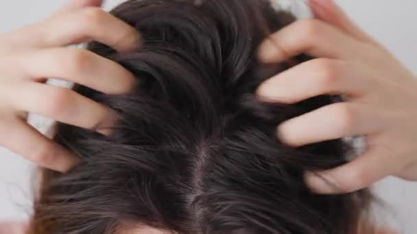 Közelről egy nő erősen vakarja a fejét a kezével.. — Stock videók