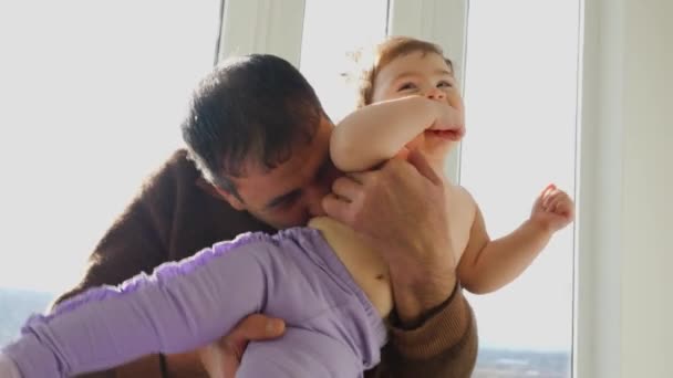 연로 한 할아버지가 어린 손자를 팔에 안고 함께 노는 모습. — 비디오