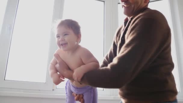 Äldre man leker med sitt barnbarn, håller honom i luften — Stockvideo