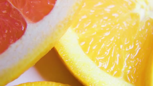 Fechar muitas fatias de frutas cítricas frescas coloridas laranja, toranja — Vídeo de Stock
