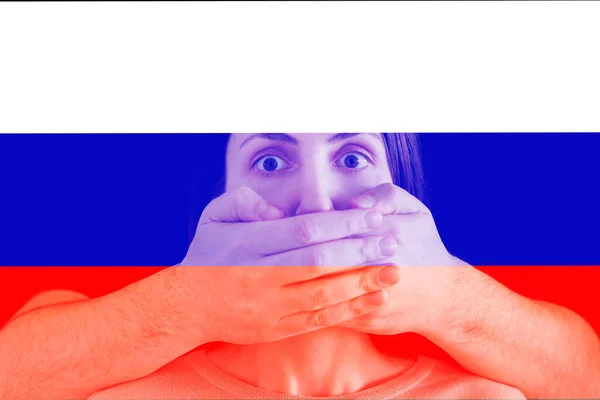 Мужская рука закрывает женский рот, русский флаг на заднем плане. цензура — стоковое фото