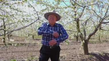 Şapkalı yaşlı çiftçinin portresi ellerini çapraz yapıyor.