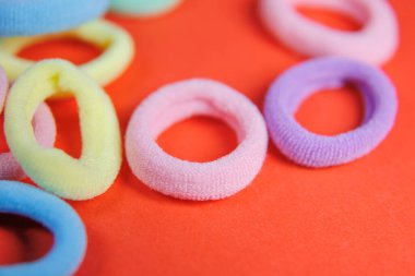 Kırmızı arkaplanda kauçuk bantlar var.