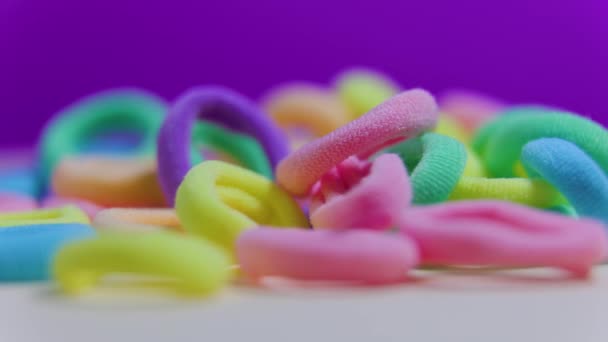 Roterande närbild textil gummiband på violett bakgrund. — Stockvideo
