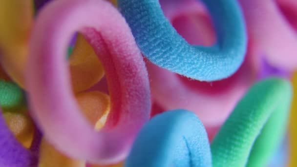 Lodrät vy över en levande färger roterande närbild textil gummiband. — Stockvideo