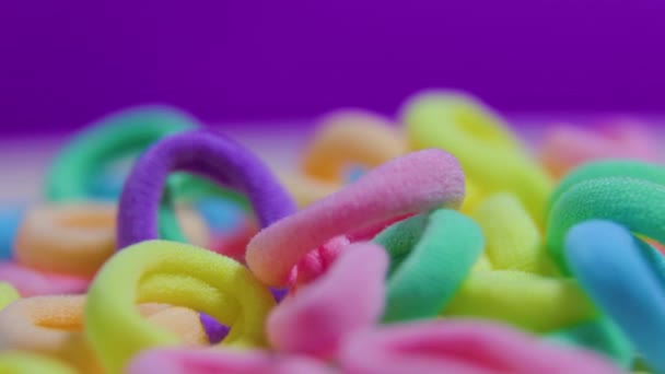 Bandas de goma multicolores imagen abstracta sobre el fondo violeta — Vídeos de Stock