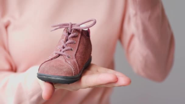 Zblízka, dětské karmínové boty. Narozeninový dárek. — Stock video