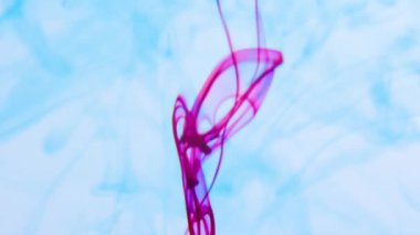 Yavaş çekimde suya gerçek renkli renkli mürekkep damlaları düşer..