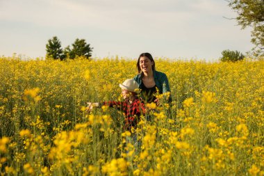 Mutlu anne ve çocuk tarımda kolza tohumu ile koşuyor..