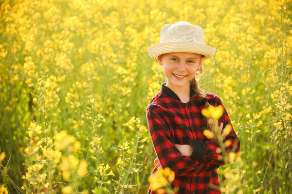 A child with a hat and cross hands, looking at the camera — Stock Photo, Image