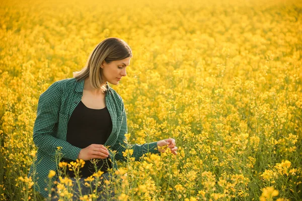 Young adorable woman farmer investigate rapeseed crop — Stock Photo, Image