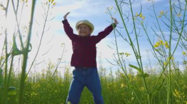 Kız gün boyunca sarı kolza tohumu tarlasında zıplar.