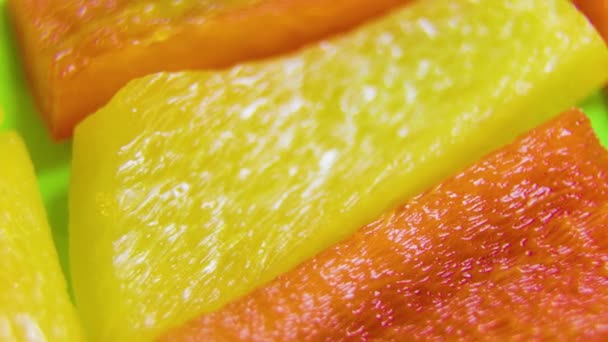 Tranches de poivron jaune, rouge et orange tournantes. — Video