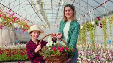 Annesi ve kızı ellerinde güzel bir çiçek sepeti tutuyorlar. Yapılan sepetten memnunlar..