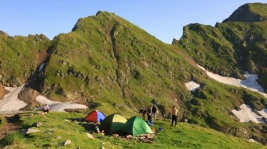 4k time lapse with the view of the huge mountain and colorful camping tents. real People are walking, Camping in mountains time lapse. valley landscape in summer