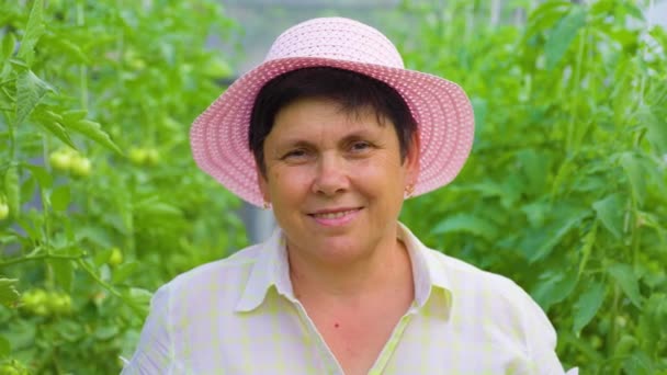 Kameraya Bakan Pembe Şapkalı Oldukça Mutlu Bir Bahçıvan Kadın Hasat — Stok video