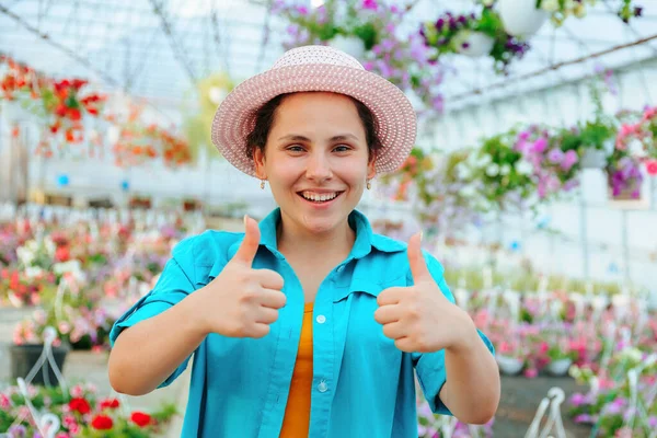 Pretty Women Stands Greenhouse Flowers Smiles Broadly Looks Camera Shows —  Fotos de Stock