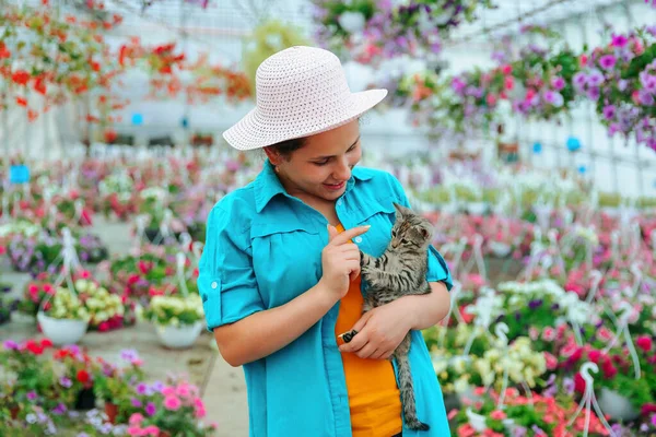 Joyful Young Lady Greenhouse Flowers Holds Gray Kitten Her Hands —  Fotos de Stock