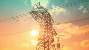 Elektrik direkleri ve elektrik santraliyle birlikte Zaman Hızı çok renkli güç şebekesi. Parlak günbatımının 4 km 'lik zamanlaması. Elektrik çelik kulesiyle..