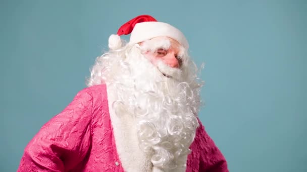 圣诞老人疲惫不堪地站在那里 背景是蓝色的 鼻子是红色的 胡子是白蓬松的 弗罗斯特神父有很多工作 圣诞节和新年都很担心 前视摄像头 — 图库视频影像