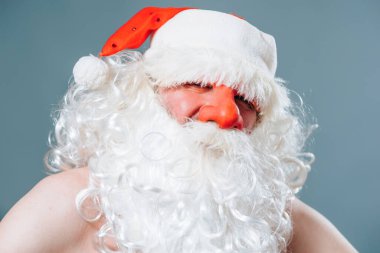 Ön manzara mavi arka plan. Kameraya bakıyorum. Kırmızı burunlu Noel Baba 'nın yakın portresi. Peder Frost 'un etkileyici bir bakışı var. Tatiller yaklaşıyor..