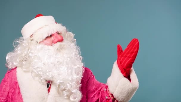 Голубом Фоне Спереди Направо Стоит Санта Клаус Большой Белой Бородой — стоковое видео