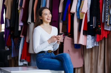 Önden bakınca iki elinle telefonu tut, genç ve güzel bir kız, parlak bir fikirle çıkageldi. Şirin kız iyi bir ruh hali için kendine ilginç şeyler seçmek istiyor..