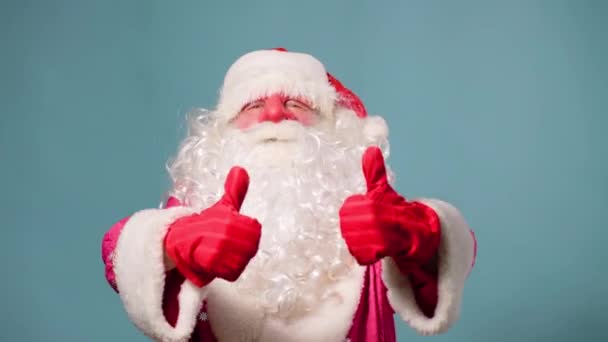 Санта Клаус Пай Натал Стоїть Синьому Фоні Дивиться Великий Фотоапарат — стокове відео