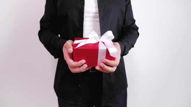 Close-up footage with man in black holding in hand red gift box and gives it. — Stock Video