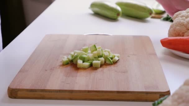 Frau Sammelt Die Gewürfelte Zucchini Ein Und Legt Sie Eine — Stockvideo