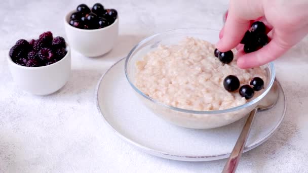 Putting Blackcurrants Black Raspberries Glass Bowl Oatmeal High Quality Footage — Vídeos de Stock