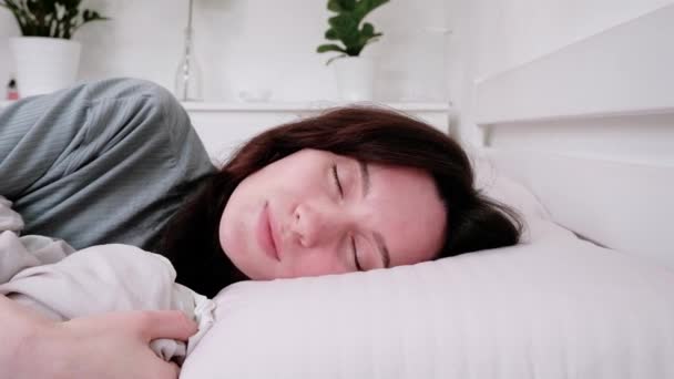 Κοντινό Πλάνο Μια Όμορφη Γυναίκα Ξυπνάει Στο Κρεβάτι Και Χαμογελάει — Αρχείο Βίντεο