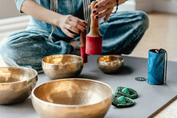 Женщина, играющая на тибетских чашах для пения на коврике для йоги, концепция духовного исцеления Стоковое Фото