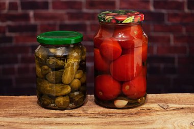 Ev yapımı salatalık ve domatesli cam kavanozlar.