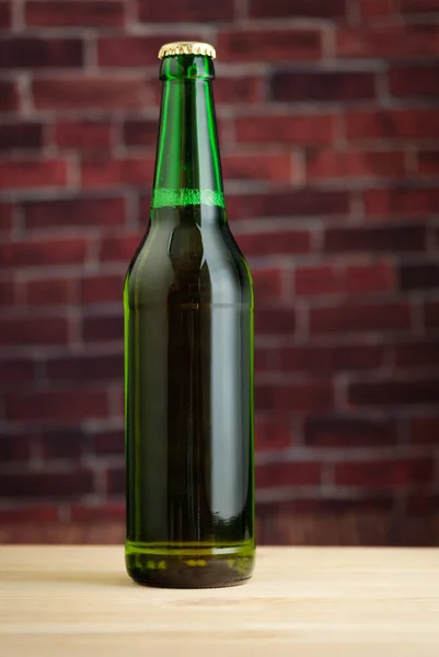 Πράσινο Γυάλινο Μπουκάλι Μπύρα Στο Φόντο Ενός Τοίχου Από Τούβλα — Φωτογραφία Αρχείου