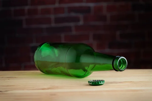 Eine Leere Gläserne Bierflasche Auf Einem Holztisch Gegen Eine Ziegelwand — Stockfoto