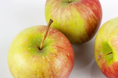 Hafif bir arka planda üç olgun lezzetli elma.