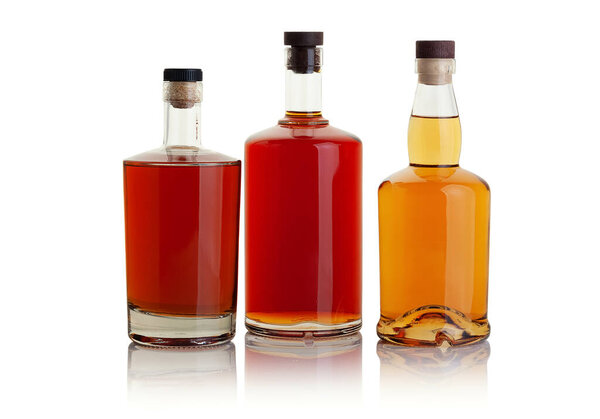 Full bottles of brandy and whiskey on a white background