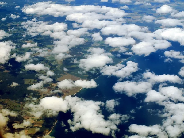 Flight over white clouds and Brosarp city in Sweden — Stock Photo, Image