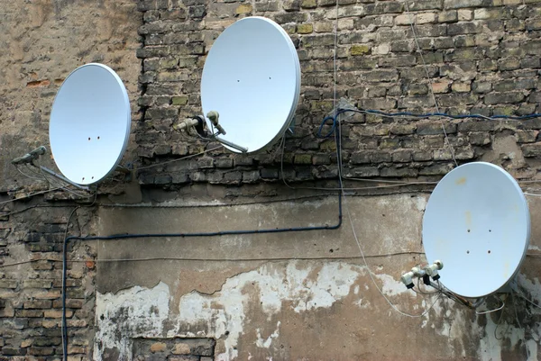 Satelliet schotel-antenne op de oude huis muur — Stockfoto