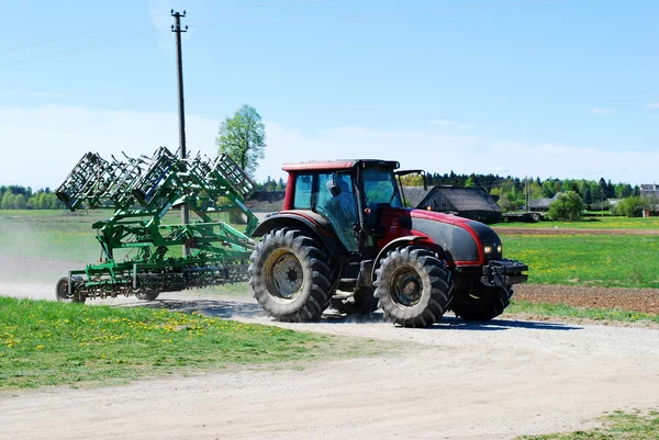Großer Traktor fährt an einem schönen blauen, sonnigen Tag zur Arbeit — Stockfoto