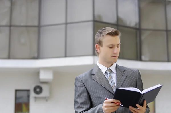 Geschäftsmann hält Notizbuch in der Hand — Stockfoto