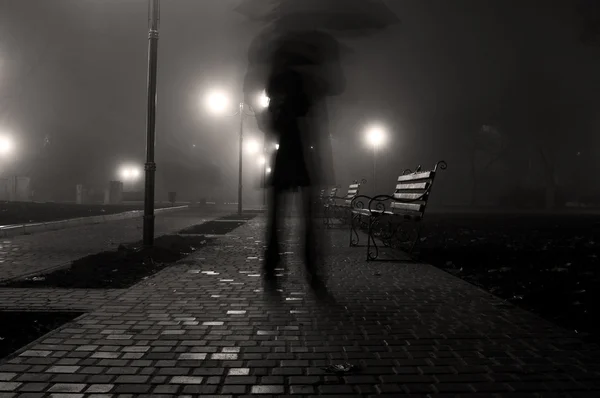 Mann mit Regenschirm im Nachtpark — Stockfoto