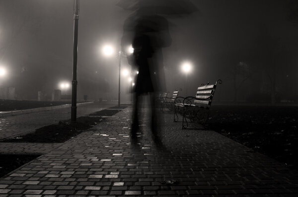 Man with umbrella in the night park