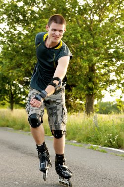 Young man with inline skates in summer clipart