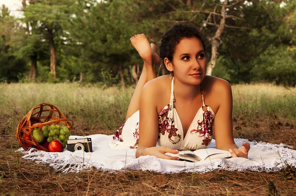 Esmer güzel kadın bir çayır üzerinde kitap okuma — Stok fotoğraf